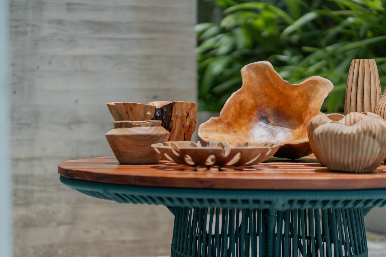 A collection of wooden bowls and vases on a rustic table, featuring natural decor and organic design elements.